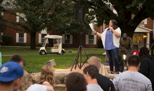 woman speaking outside to a group of students