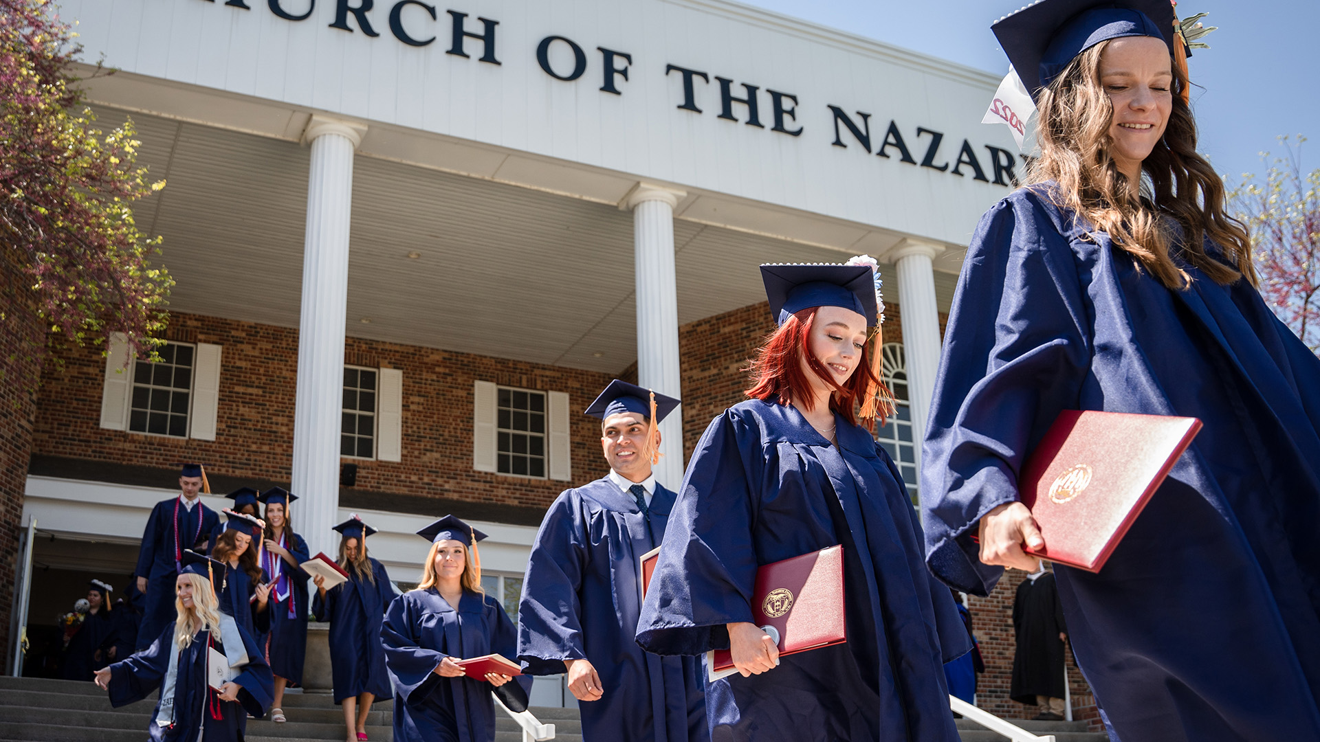 happy graduates on steps leaving ceremony