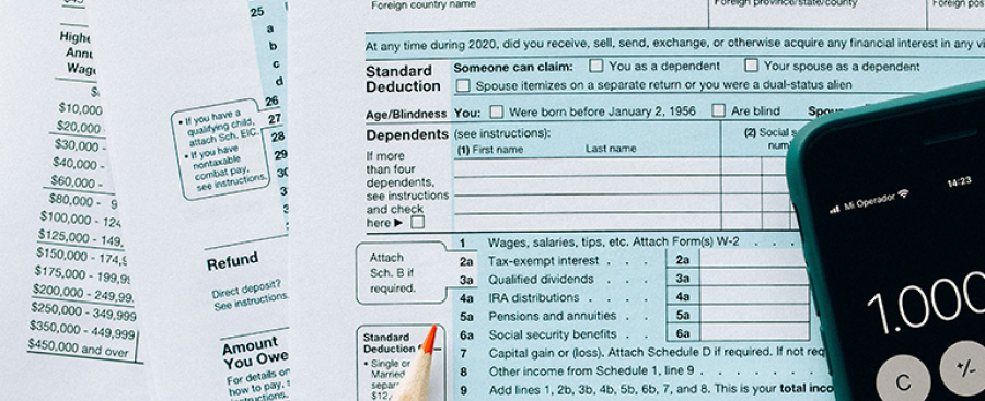 Tax forms and a calculator app on a phone