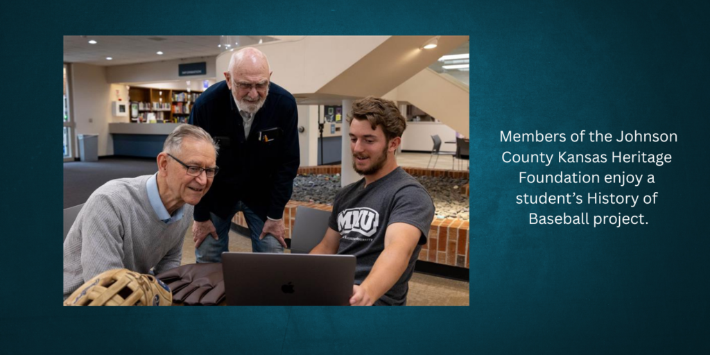 Two older gentlemen look at laptop with MNU history student