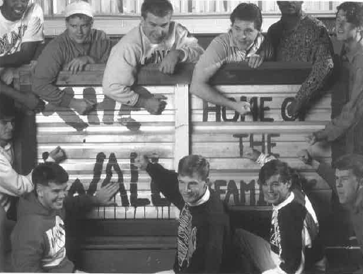 The Wall Family sign with a group of people posed around it.