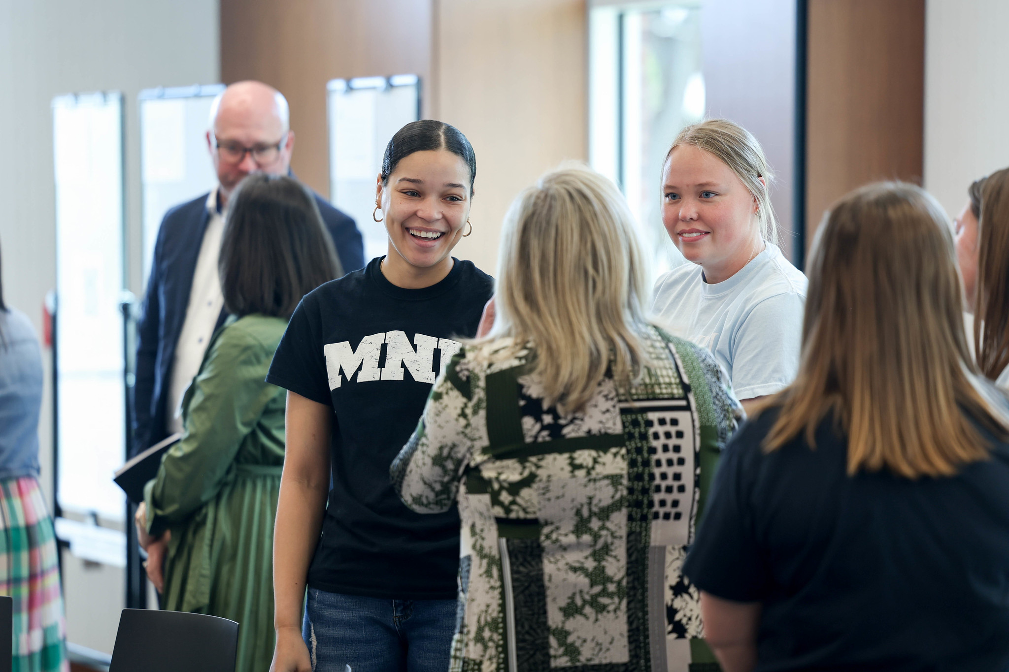 Education influencers speaking in a group at a lunch event at MNU