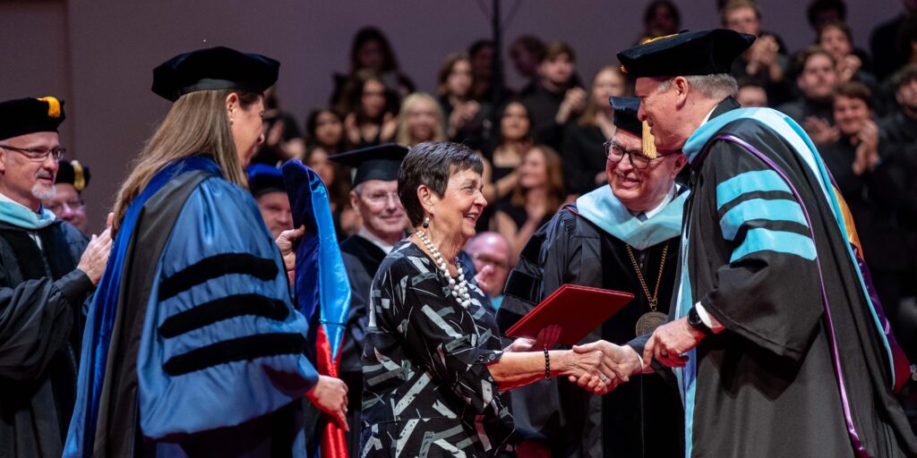 Donna Spittal receives honorary doctorate from Board Chair Dan Rexroth.
