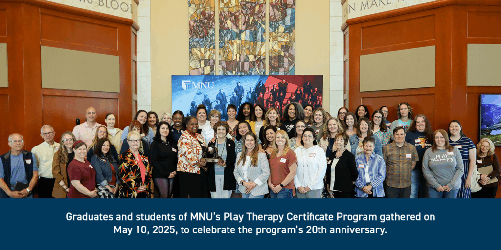 Large group of graduates and students of MNU's Play Therapy certificate program pose together at Bell Center.
