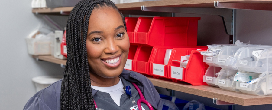A nursing student smiling while gathering supplies