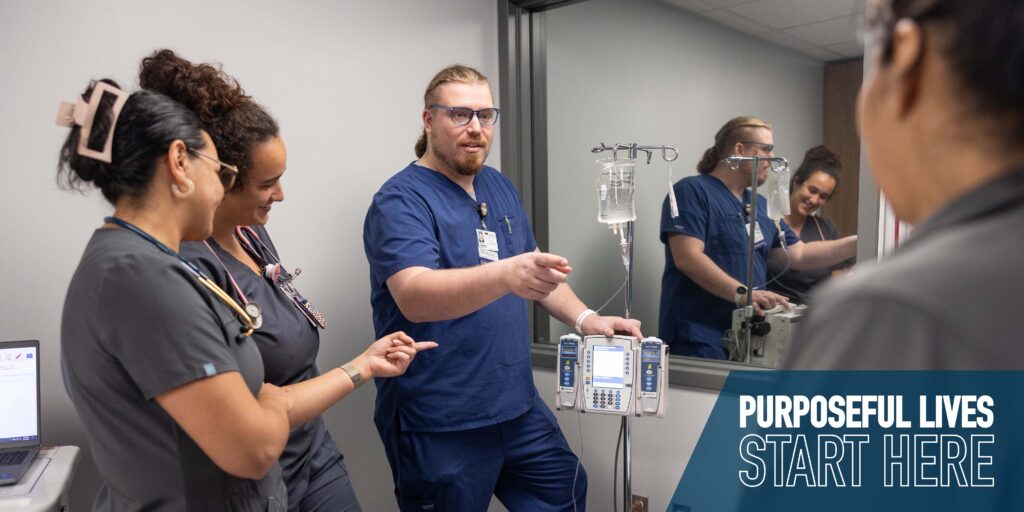 Jared Kellum instructs three nursing students on IV equipment