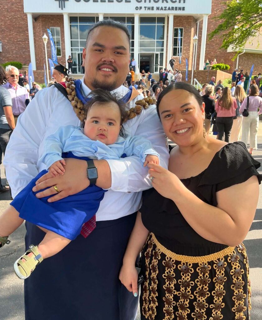 Apa Visinia, Jr, holding son Sola with wife Lela at MNU Commencement 2025.