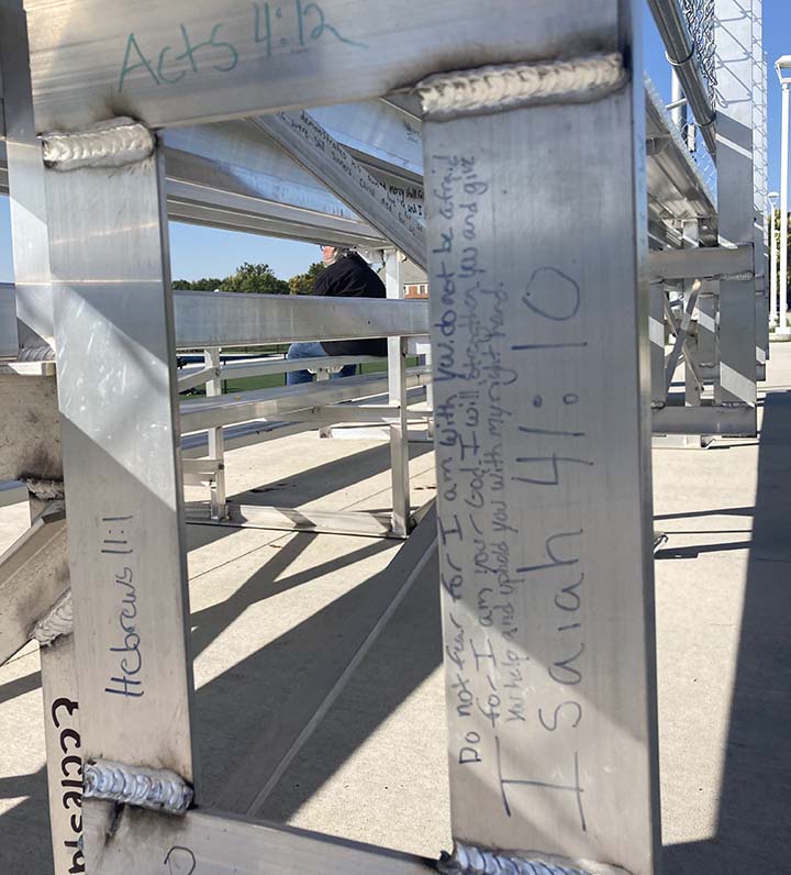 photo of Bible verses on bleachers in football stadium