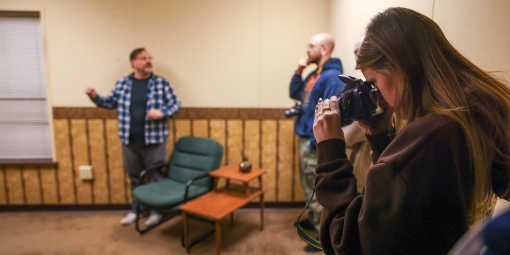 Students take photos at staged crime scene in forensics lab